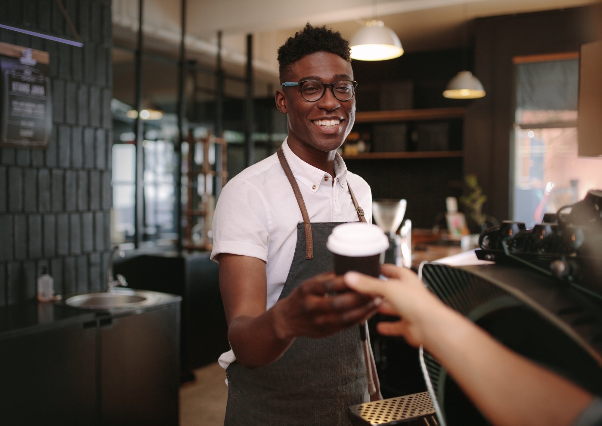 A man serving a coffee to a customer