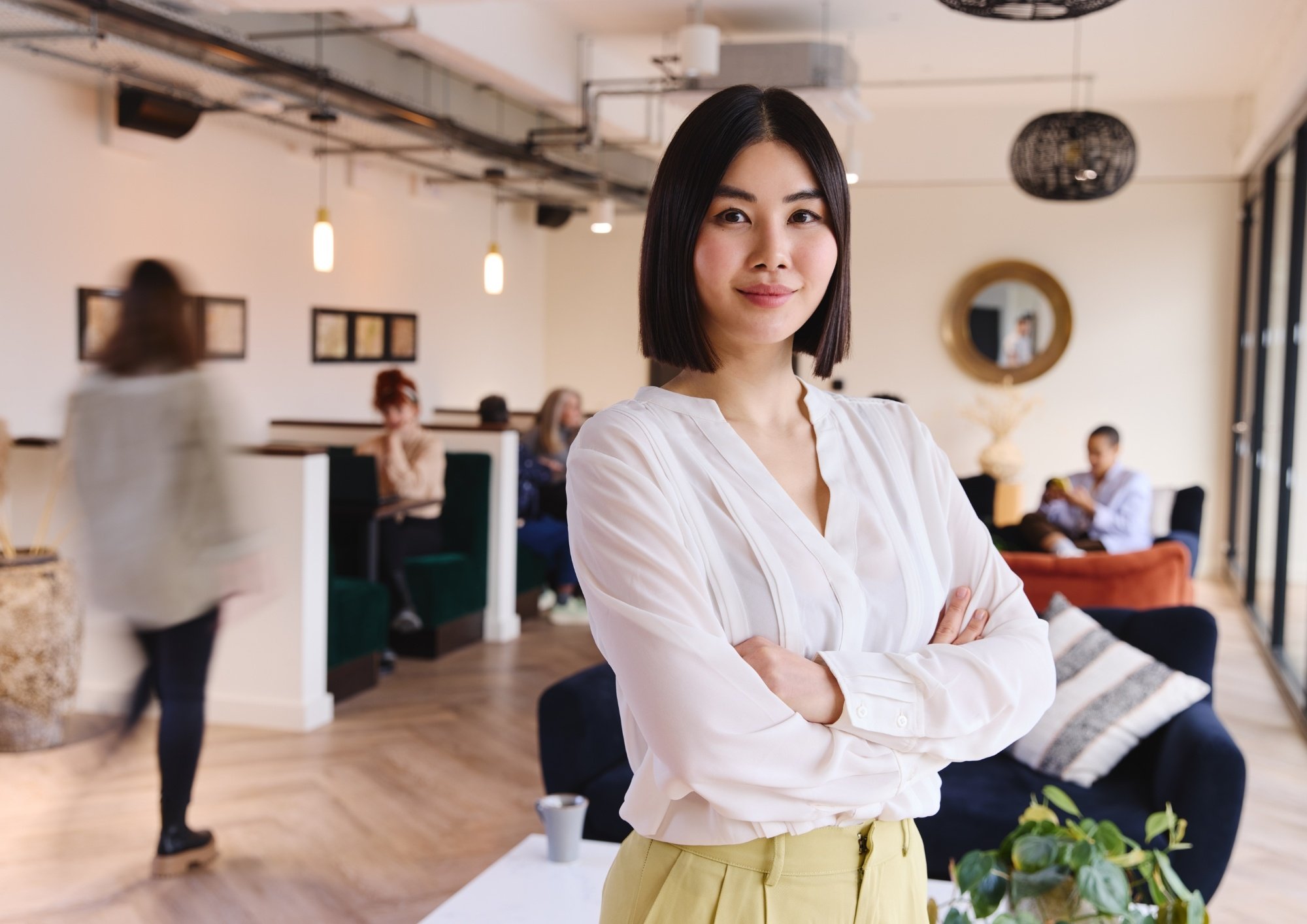 Woman in white blouse with office in the background.